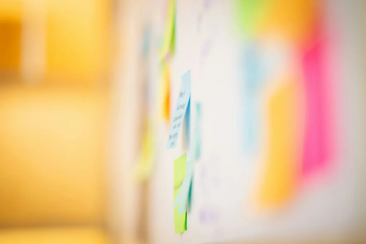 Coloured sticky notes arranged across a white wall
