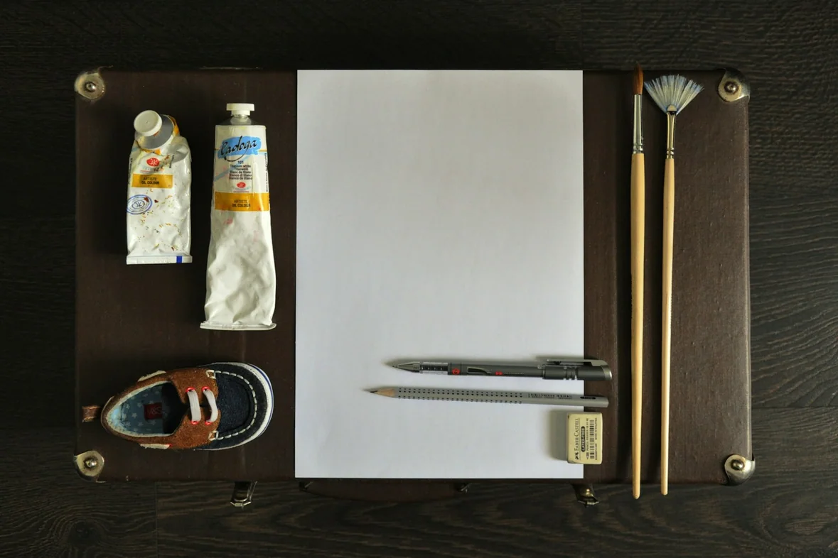 A notepad, pencils and a pair of scissors arranged on a desk