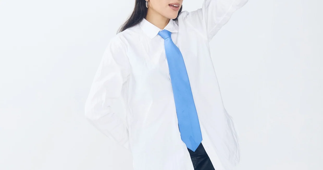 A woman in a white shirt taking a selfie video on a phone