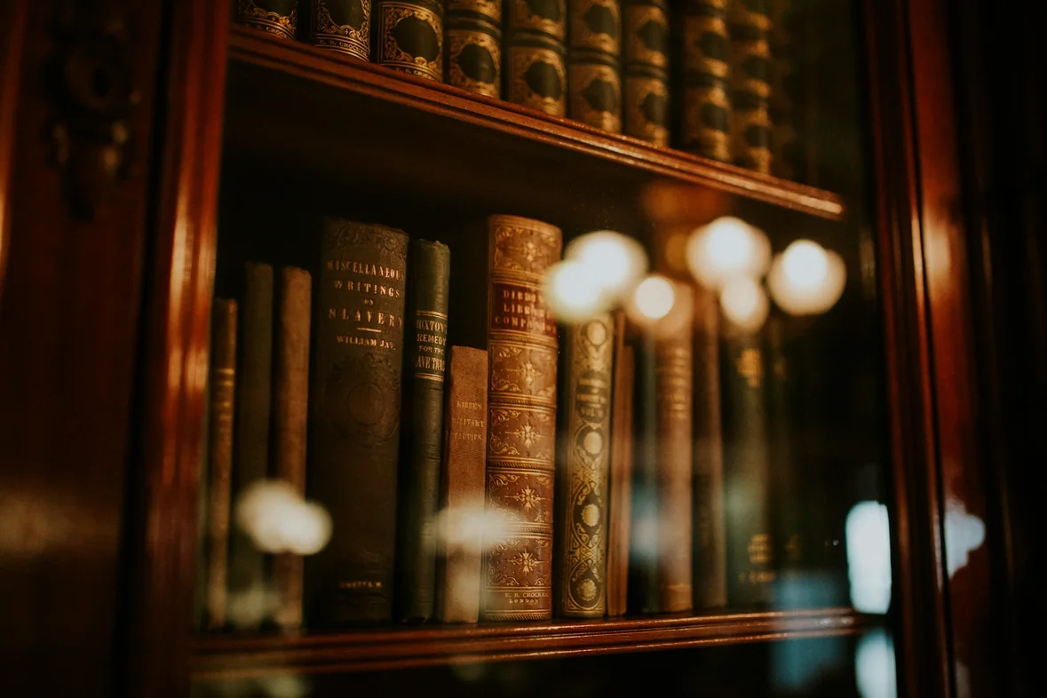 Rows of leather-bound legal books behind the glass doors of a wooden bookcase