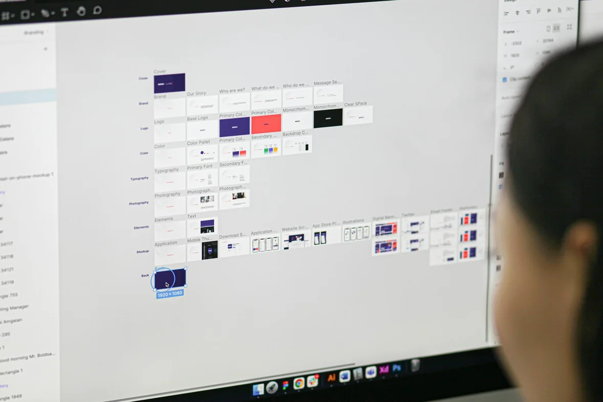 A person looking at a monitor filled with a dense colour-coded scheduling grid