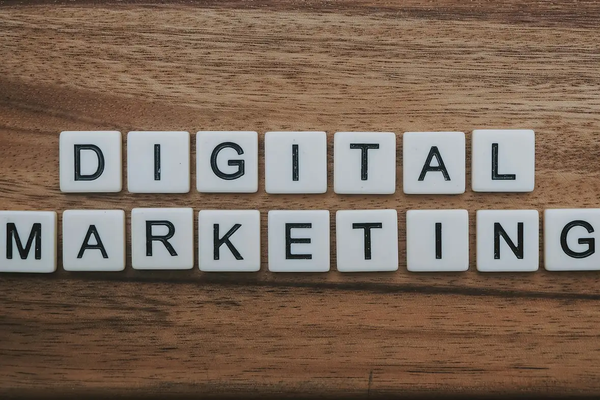 Lettered tiles arranged on a dark wooden surface spelling the words digital marketing