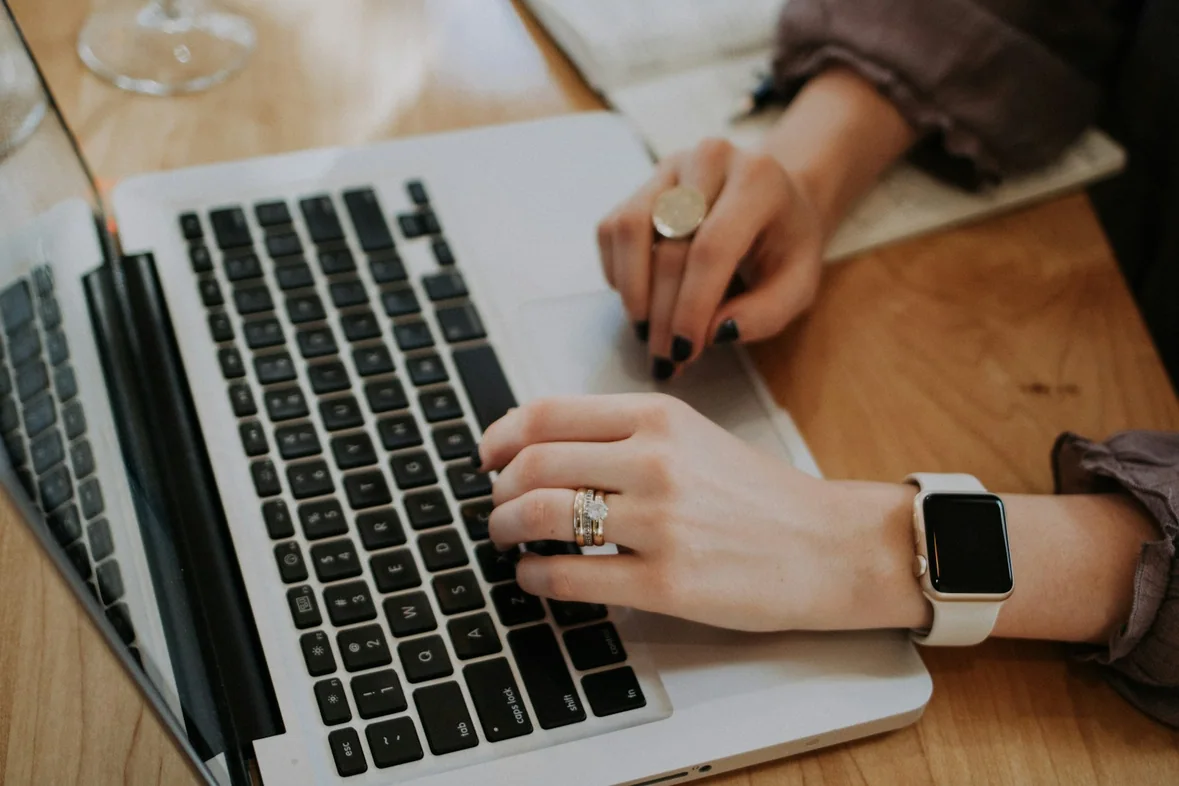 Someone using a laptop, hands resting on the keyboard