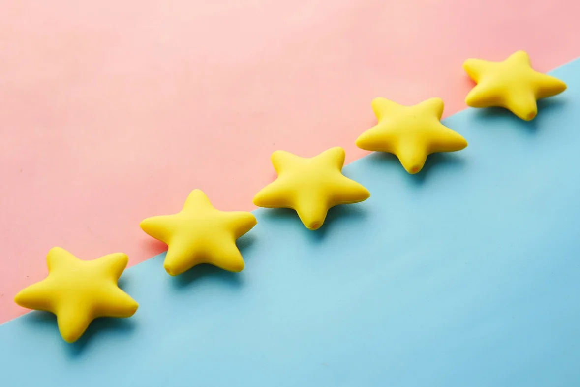 Five yellow star shapes arranged in a rising row against a pink and blue background