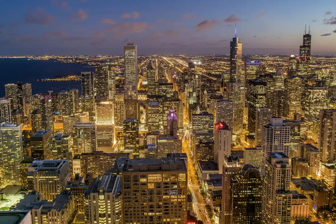 Chicago high-rise buildings viewed from above at dusk with lit streets between them