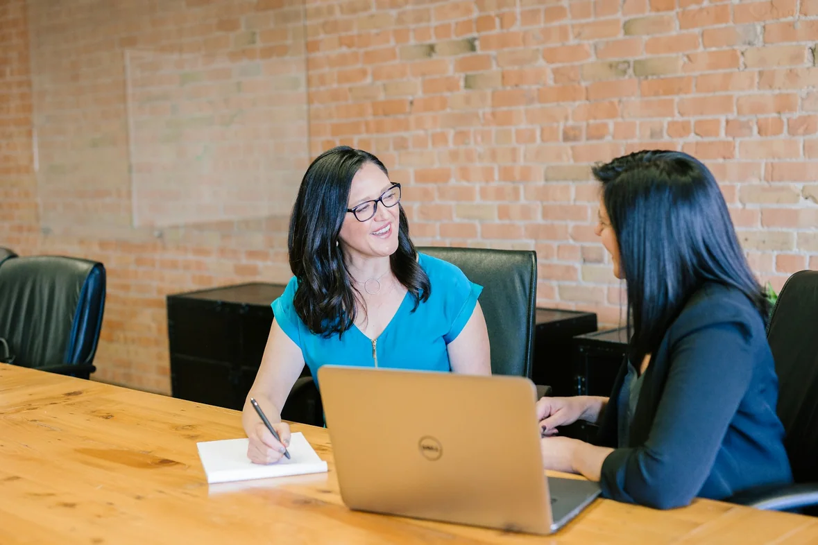 Two colleagues sitting side by side reviewing something together