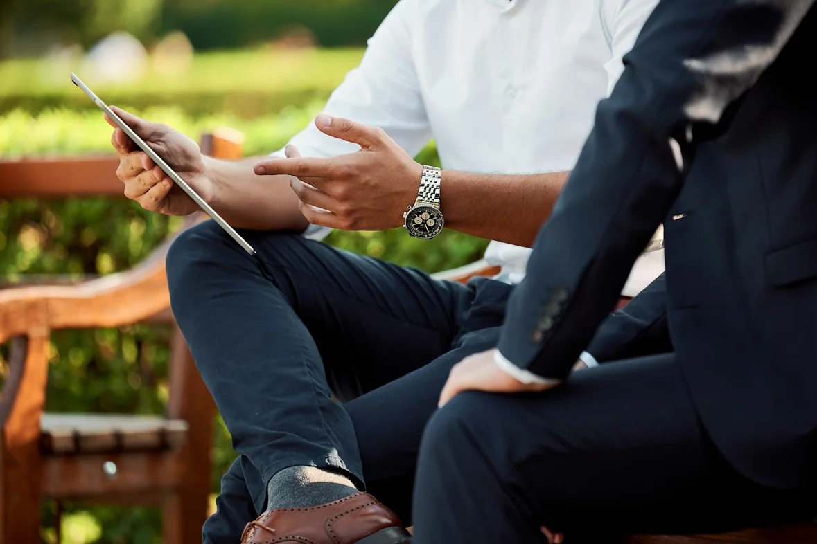 Two people sitting and talking in daylight, papers between them