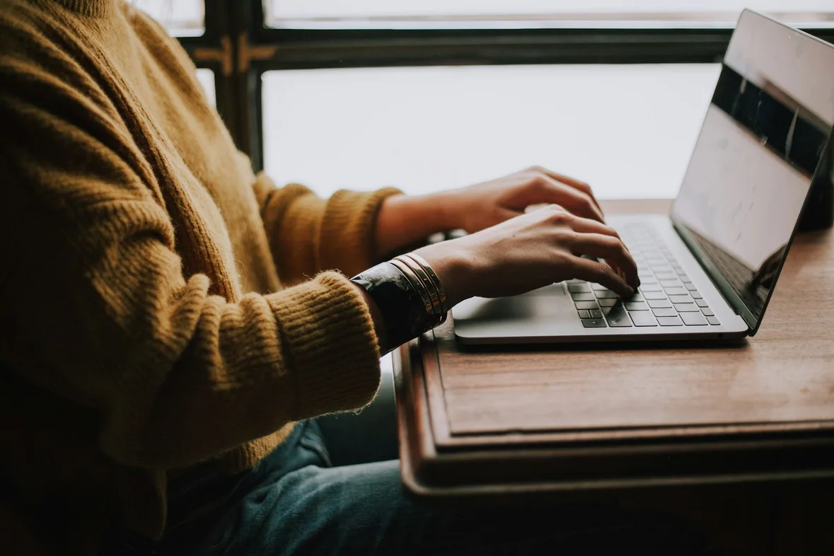 Someone seated in front of a laptop, concentrating