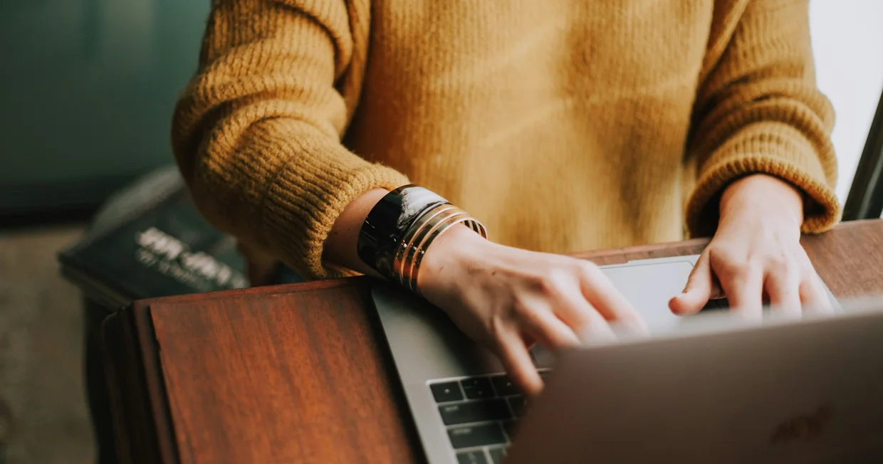 A person working at a laptop in a quiet workspace