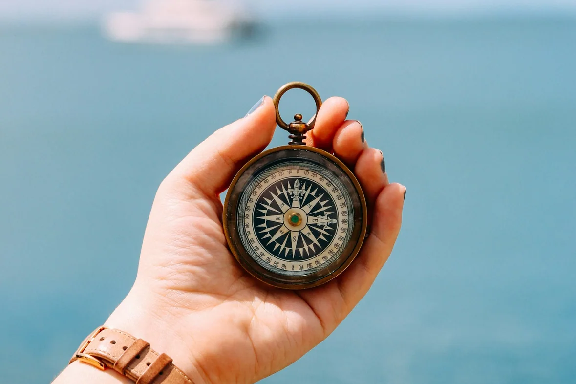 Someone holding a compass, the dial catching the light