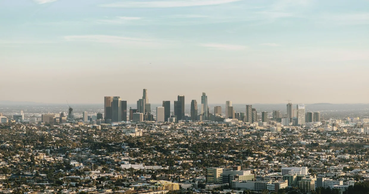 The Los Angeles skyline under a clear sky, downtown towers rising above the surrounding city