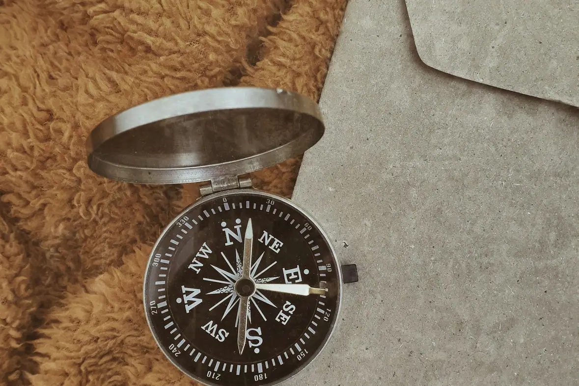 A compass lying on top of a sheet of paper