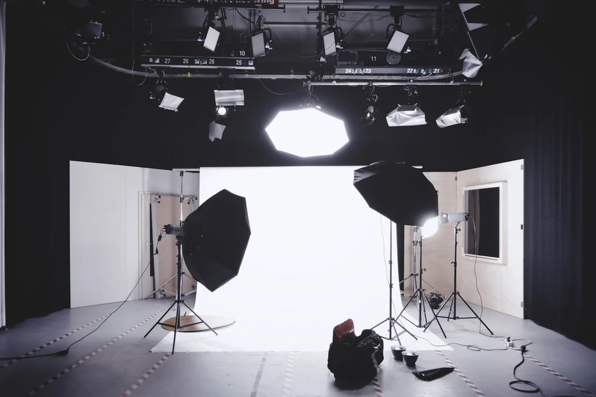 A camera and lighting set up in a small studio space