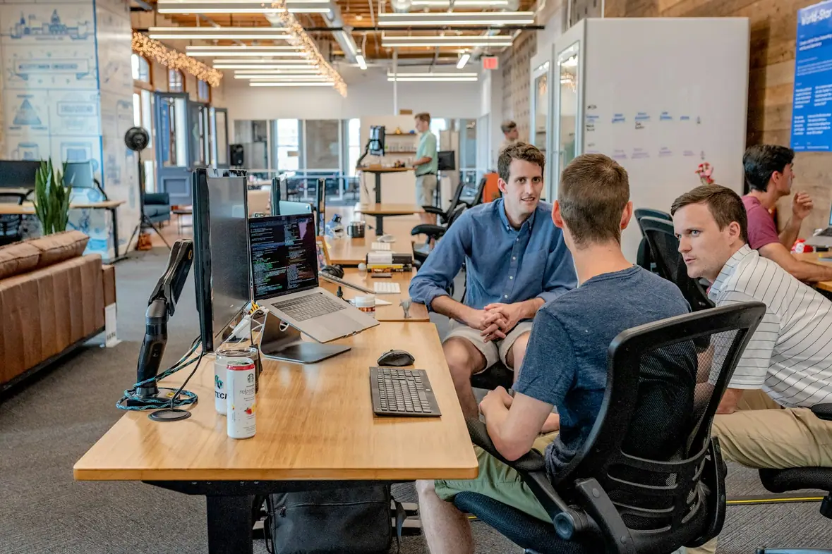 Three colleagues seated at desks working beside one another