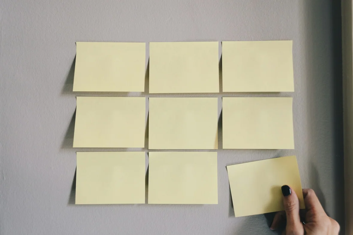 Six plain white sticky notes on a pale surface