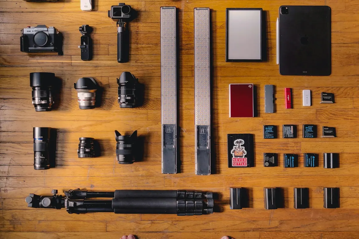A camera and accessories laid out on a wooden surface