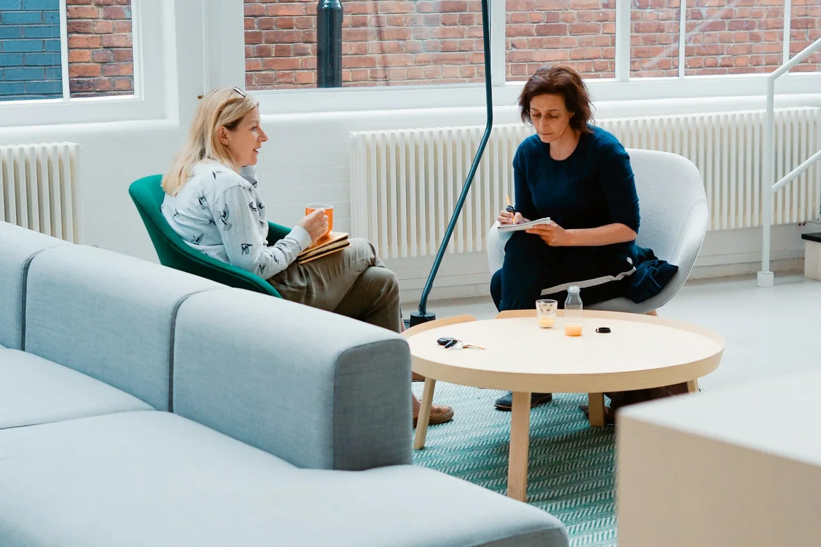 Two people sitting in armchairs in conversation