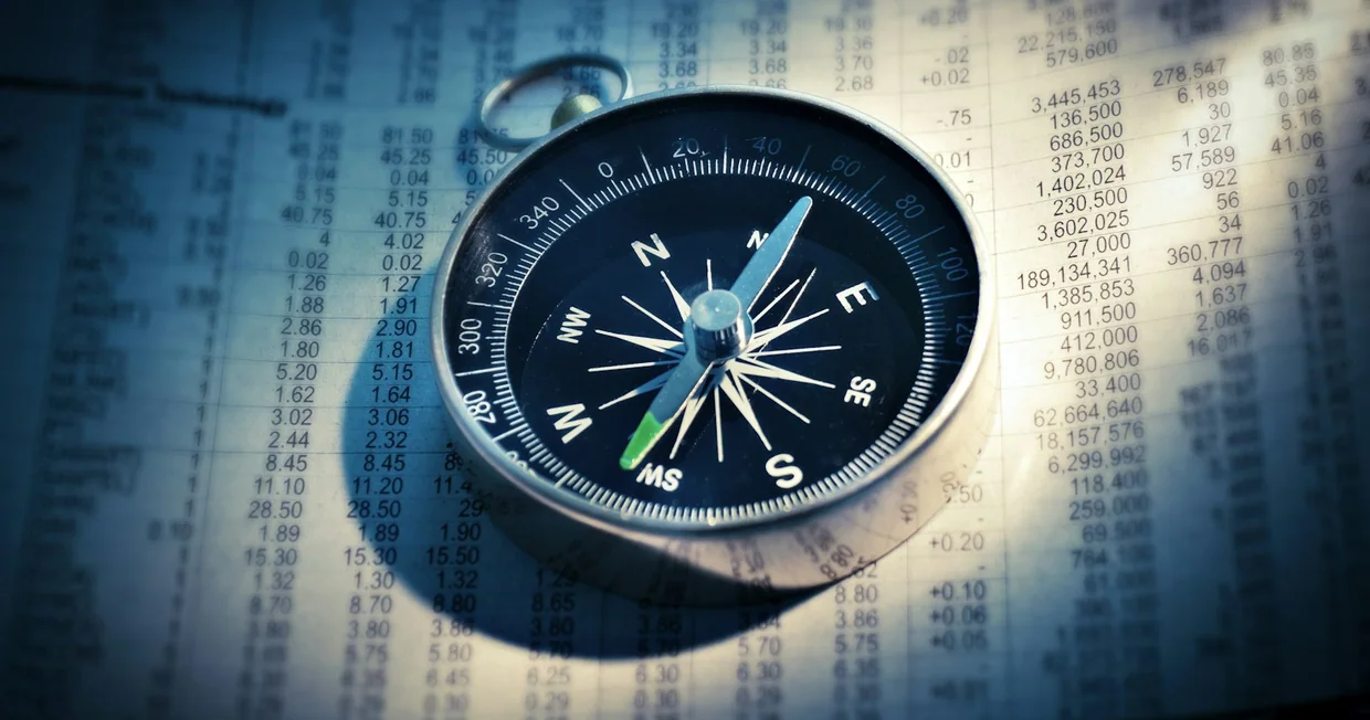 A black and grey compass photographed in shallow focus