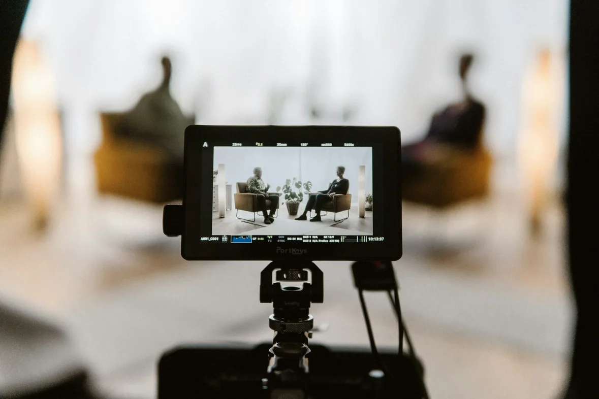 A camera mounted on a tripod pointed at a workspace