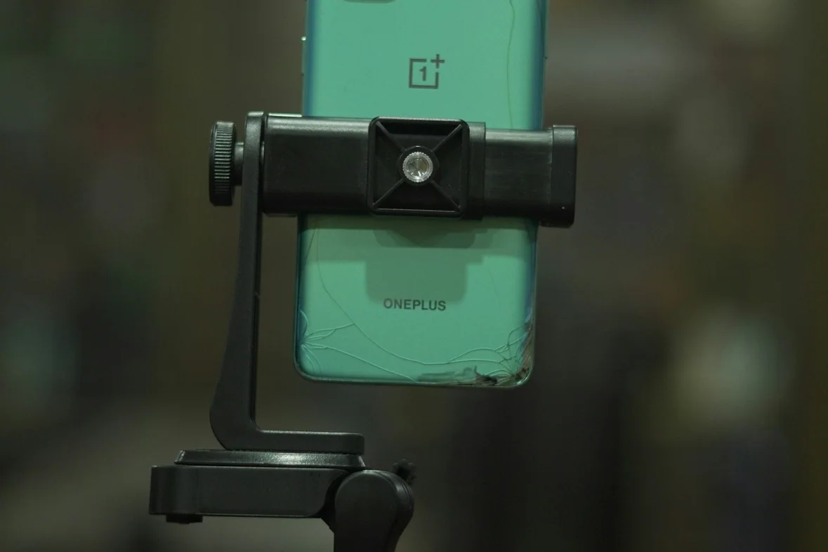 A smartphone clamped to a tripod arm ready to film