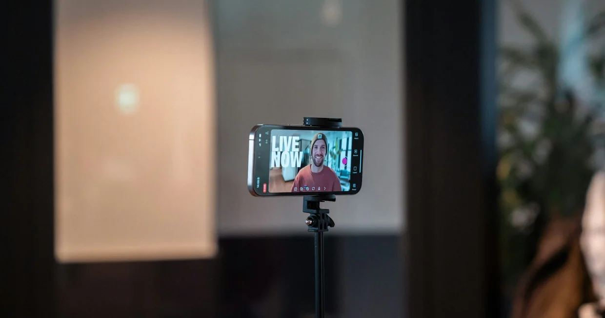 A smartphone mounted on a tripod recording a person speaking