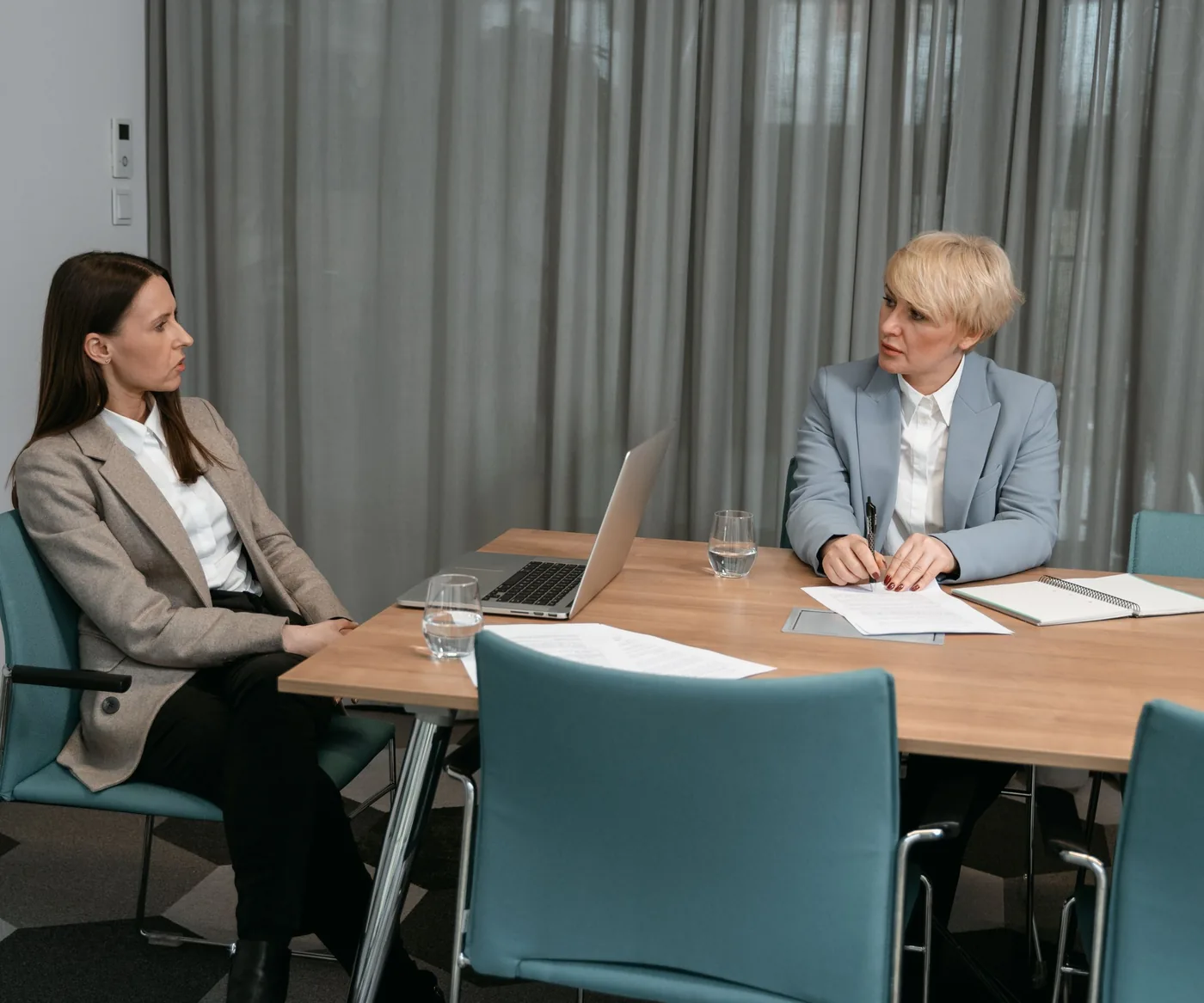 Two people talking across a table in a quiet meeting room