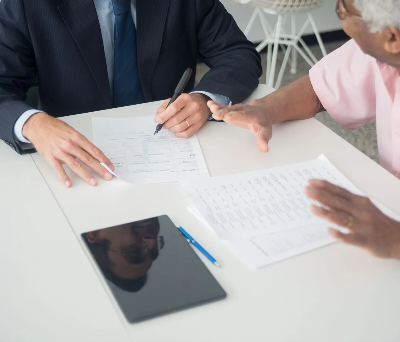 An adviser and a client going through paperwork together at a table