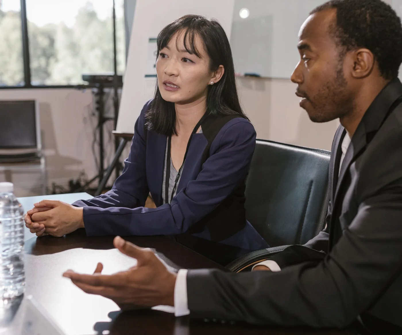Two people in conversation across a meeting-room table